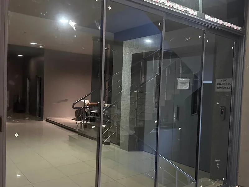 Mağaza girişi temperli cam kapı — Koyu cam vitrin sistemi. Zafer Alüminyum Sivas uygulaması